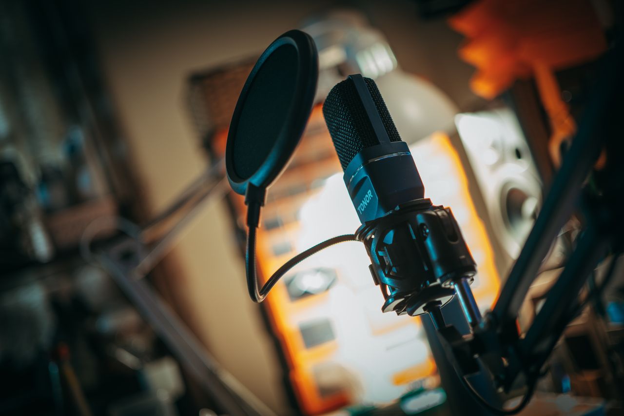 Close-up of a microphone with pop filter in a recording studio, perfect for music production visuals.